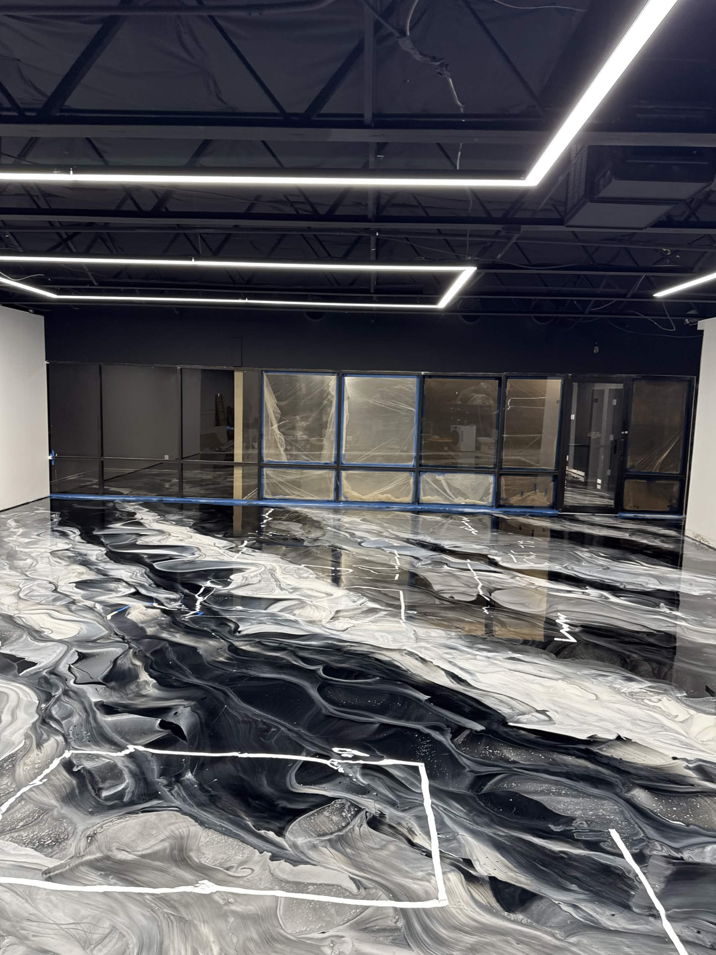 Black and white metallic epoxy commercial floor with dramatic marble swirls and high-gloss finish installed by IronCoat Epoxy Co. in DFW