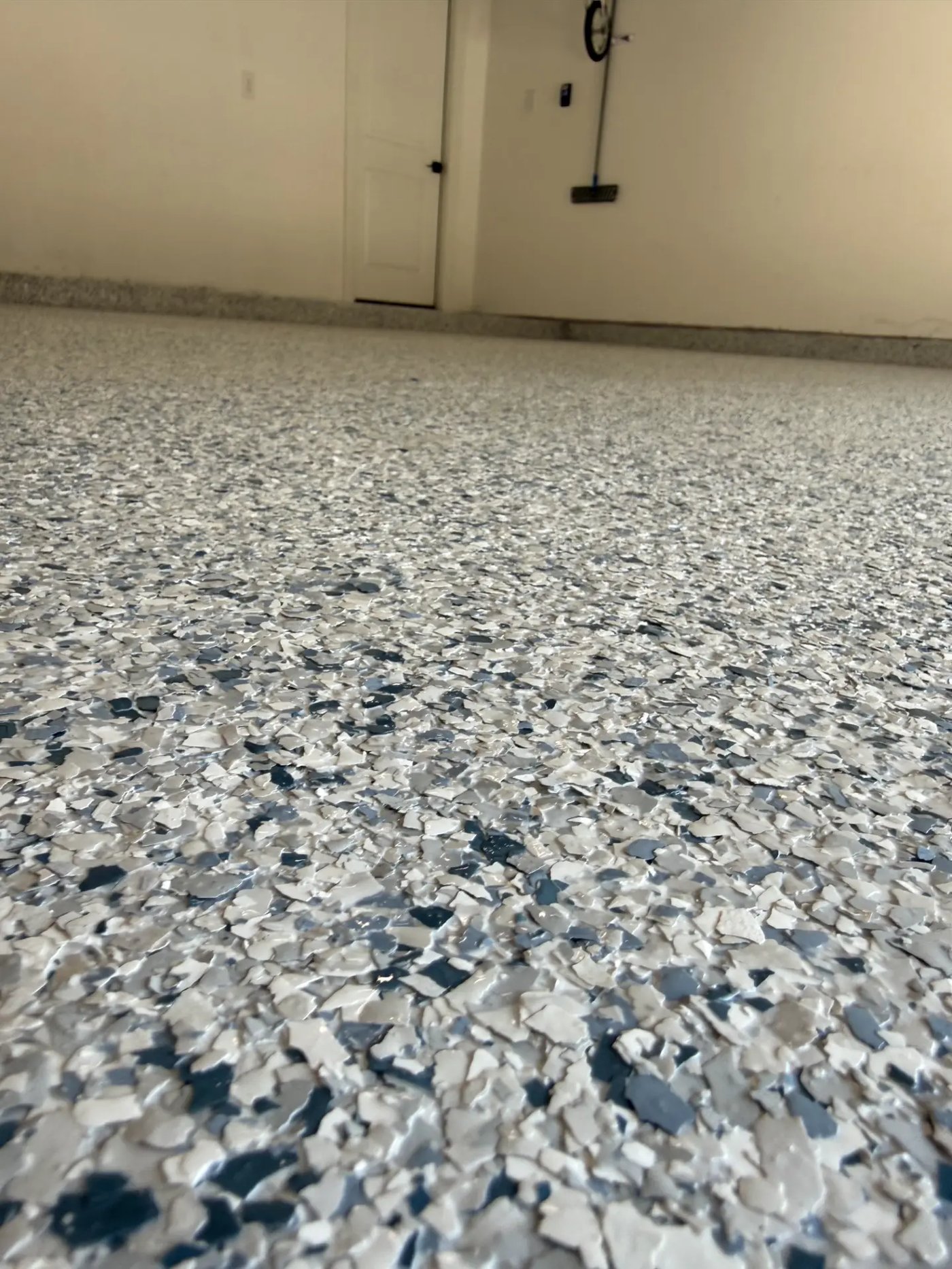 Close-up of blue, white and gray full-flake epoxy garage floor with glossy topcoat installed by IronCoat Epoxy Co. in DFW