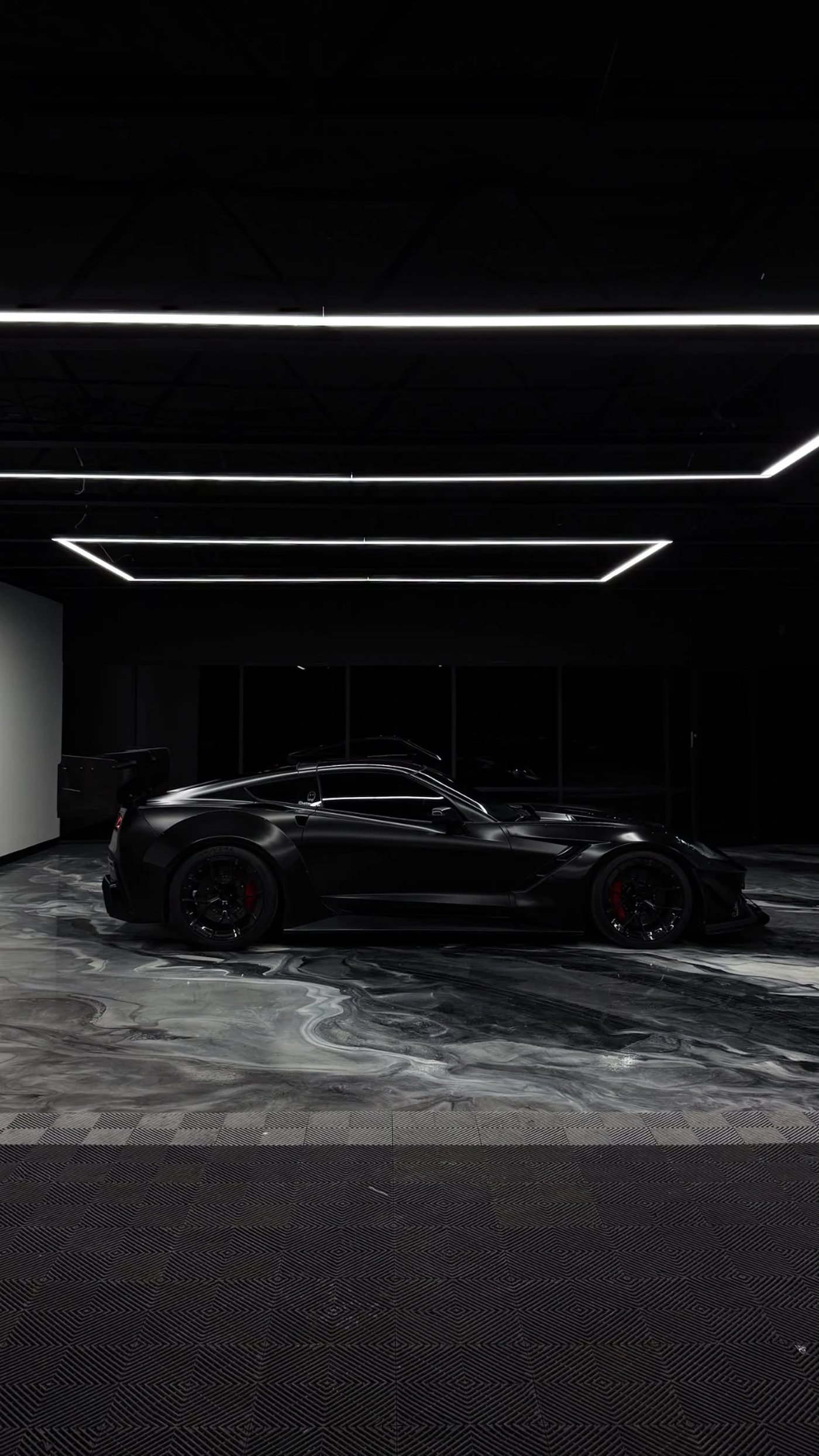 Side profile of a black Corvette on a silver marble metallic epoxy garage floor with mirror-gloss finish by IronCoat Epoxy Co. in DFW