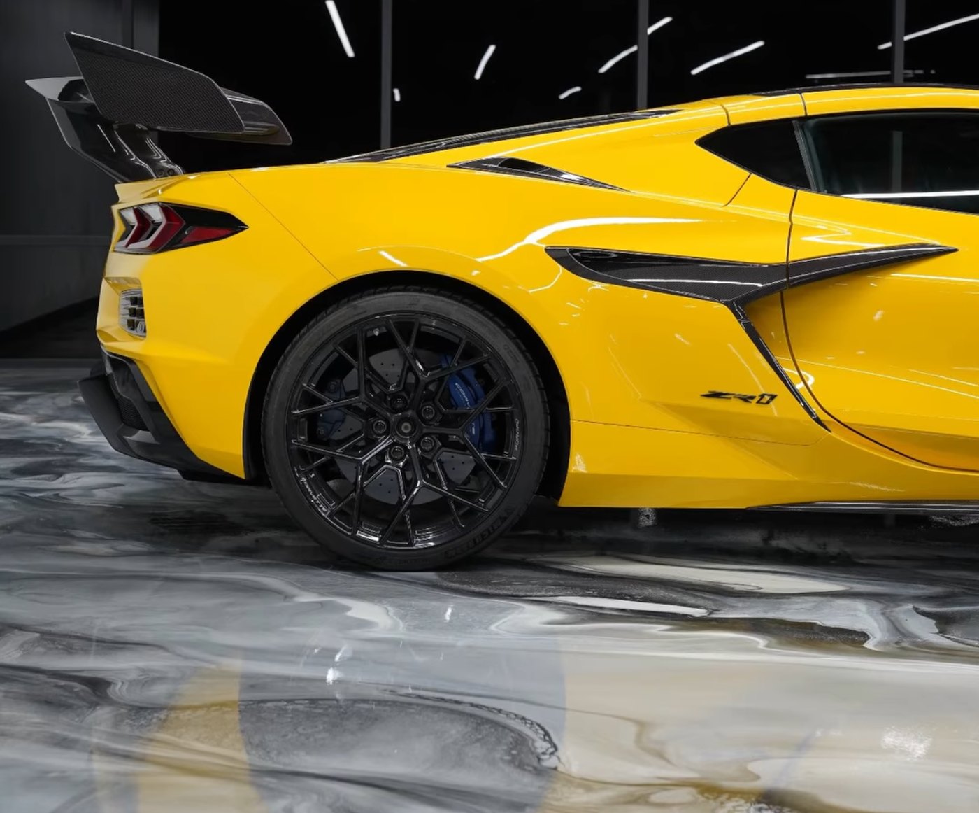 Yellow Corvette ZR1 on a marble-look metallic epoxy showroom floor installed by IronCoat Epoxy Co. in the DFW metroplex